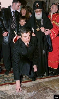 საქართველოს მესამე პრეზიდენტი მიხეილ სააკაშვილი დავით აღმაშენებლის საფლავთან, გელათის სამონასტრო კომპლექსში. 2004 წლის იანვარი.