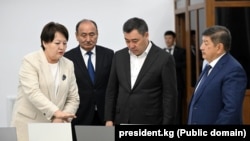 Президент Садыр Жапаров “Кыргызиндустрия” мекемеси чыгара баштаган ноутбуктарды көрүп жаткан учуру. Архивдик сүрөт