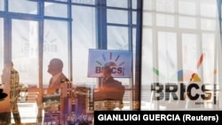 Delegatë duke kaluar pranë logos së BRICS-it, gjatë samitit të mbajtur në Johanesburg, Afrikë e Jugut, më 23 gusht 2023.