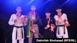 محسن رضایی با بیرق افغانستان دیده میشود که در کنار سایر مدال آوران رقابت های فستیوال تکواندوی جهان ایستاده است