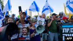 Израилдин өкмөтүнө каршы акциянын катышуучулары барымтадагылардын сүрөттөрүн көтөрүп турушат. Иерусалим, 17-июнь 2024-жыл