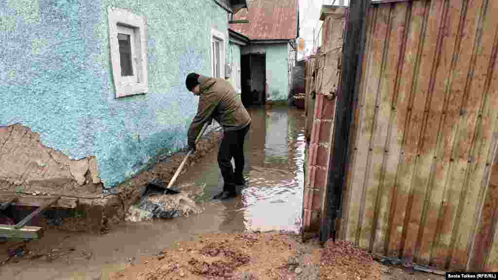 A villager clears muck near his home in Koyandy, a village some 20 kilometers northeast of the nation's capital, Astana. Residents of Koyandy took to the streets and barricaded the roads, furious at the authorities' inability to prepare for the seasonal floods.&nbsp;