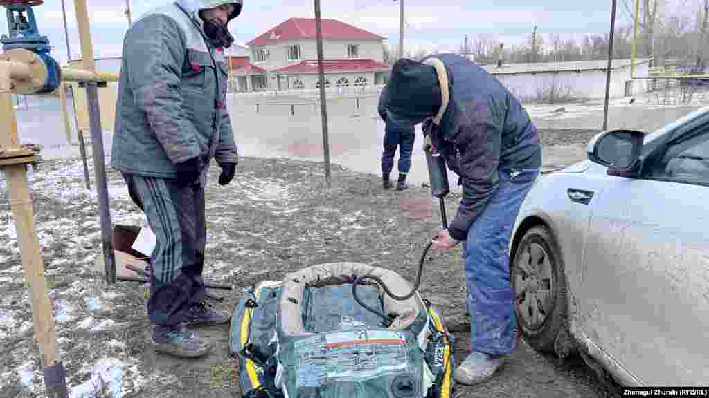 Further south of the nation's capital, a resident of Aqtobe prepares a rubber boat to reach his flooded house on the banks of the Elek River.