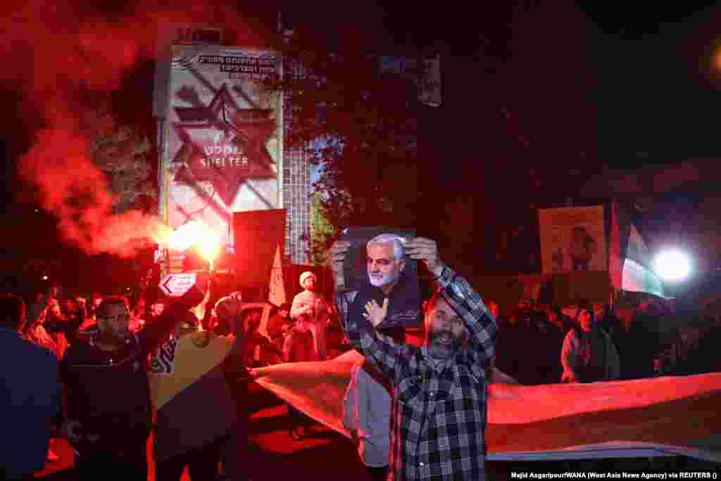 Иранец держит плакат с изображением высокопоставленного иранского командующего, генерала Касема Сулеймани. Сулеймани был убит в результате удара американского беспилотника возле международного аэропорта Багдада 3 января 2020 года, когда он ехал на встречу с премьер-министром Ирака Адилем Абдул-Махди.