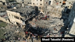 Palestinci na mjestu izraelskog napada na kuću, u Rafi u južnom Pojasu Gaze, 19. decembra 2023.