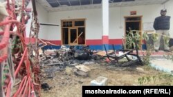 د مدین په تاڼه کې یو پولیس ولاړ دی، په انګړ کې سوځېدلي سامانونه پراته دي - د جون ۲۱مې انځور.