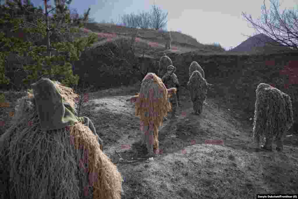 Această procesiune &bdquo;nepământeană&rdquo; este un grup de soldați ucraineni care se participă la cursul de lunetiști Alfa Bravo, într-o locație nespecificată, din apropierea frontului din Ucraina.