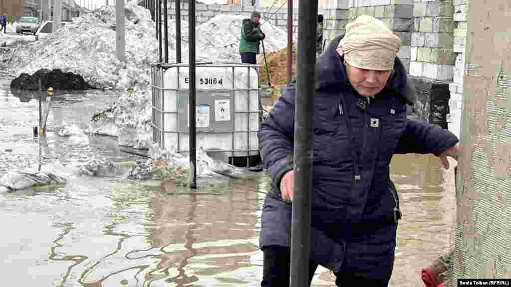 A woman struggles to make her way in Koyandy. Six protesters in the village were fined by the authorities for "participating in an illegal rally."