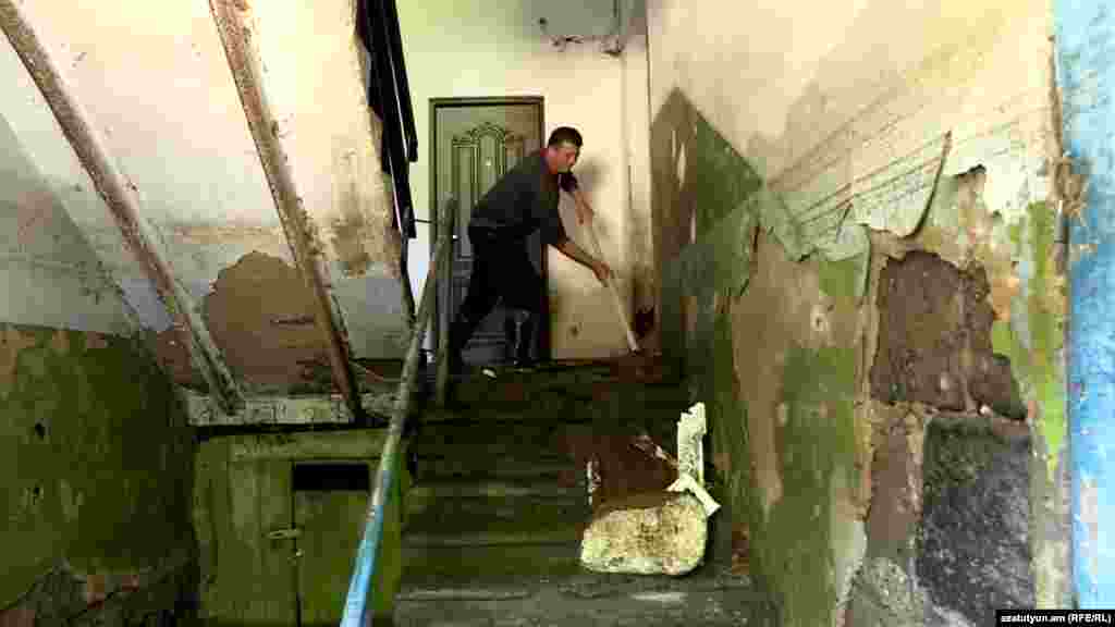 Un bărbat îndepărtează noroiul de pe o scară în orașul greu afectat Alaverdi, la 28 mai, în timp ce lucrările de curățare continuă în nord-estul Armeniei, în urma celor mai grave inundații din ultimele decenii.