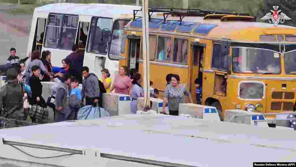 In an image released by the Russian Defense Ministry on September 20, Russian peacekeepers help evacuate refugees from Stepanakert. TASS quoted the ministry as saying its peacekeepers had evacuated more than 2,000 civilians from Nagorno-Karabakh. In a rare show of agreement with the West, Moscow called on both sides to stop the violence.