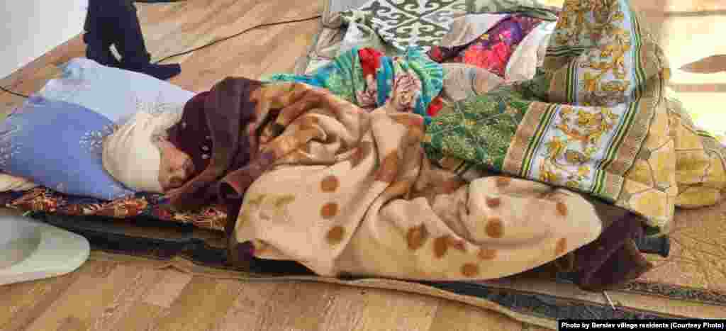 A woman sleeps on the gym's hardwood floors. Officials said the situation remains "complicated" in several regions, where floodwaters continue to rise. This year's flooding exceeds the scale of the 2012 and 2017 floods, which were considered the largest in 30 years.