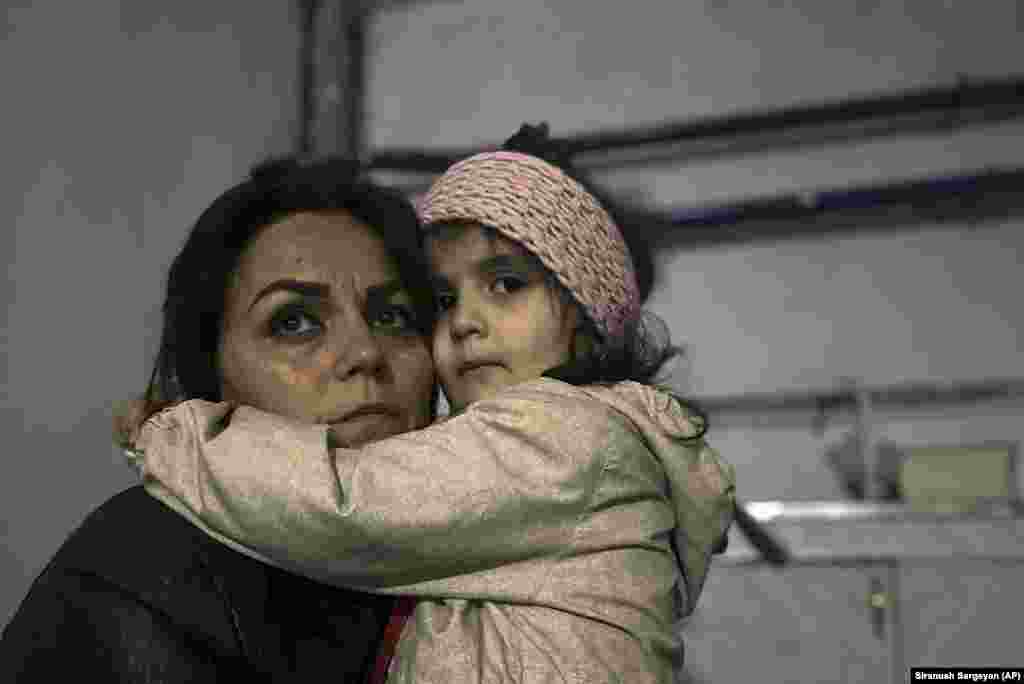 A woman embraces a child in a shelter during shelling in Stepanakert. U.S. and European leaders had long called for Azerbaijan to ease the transit of humanitarian aid to the beleaguered region, which is experiencing shortages of food, energy, and medicine.