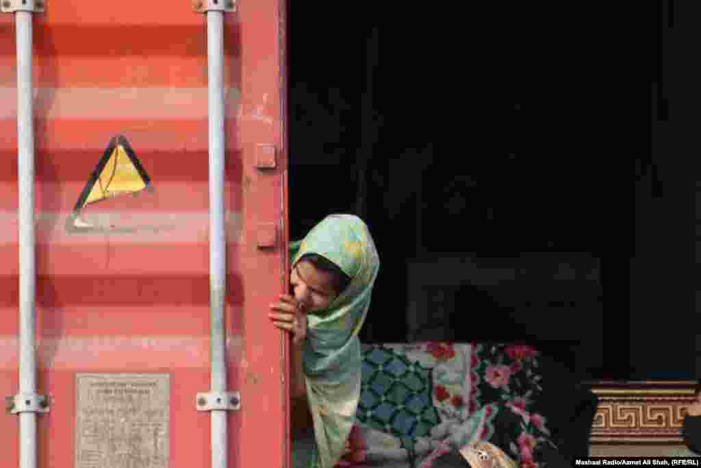 A young girl looks out from the back of a cargo container. On October 3, the Pakistani Interior Ministry announced that all undocumented immigrants in Pakistan had to leave the country within 28 days. As of October 27, about 60,000 Afghans had left Pakistan, the United Nations reported. Many of them cited a fear of arrest in Pakistan as the main reason for going back.