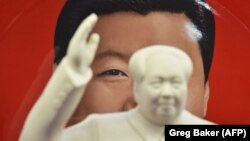 Кытайдын Коммунисттик партиясынын биринчи төрагасы Мао Цзэдундун айкелинин артында өлкөнүн азыркы лидери Си Цзинпиндин сүрөтү турат. Иллюстрациялык сүрөт.