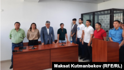 Курсан Асанов (солдон үчүнчү, көк кийимчен) жана Турсунбек Бейшенбеков (оңдон экинчи, кызыл кийимчен) сот отурумунда. Архивдик сүрөт. 8-июнь, 2023-жыл.