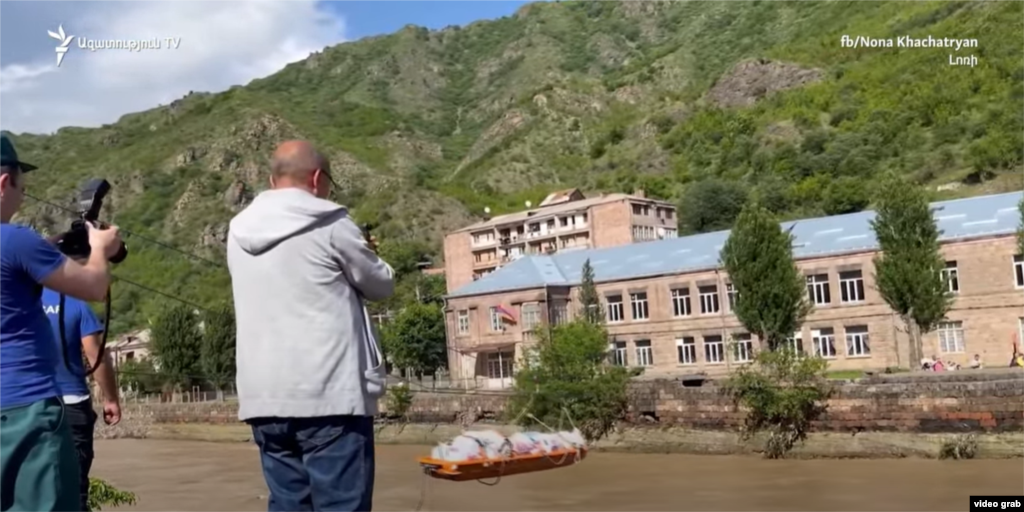 Bărbați folosesc un cablu improvizat pentru a transporta materiale peste râul Debed, în orașul Alaverdi. &nbsp;