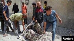 باشنده گان غزه جسد یک قربانی حمله نیروهای اسرائیلی را انتقال می دهند 