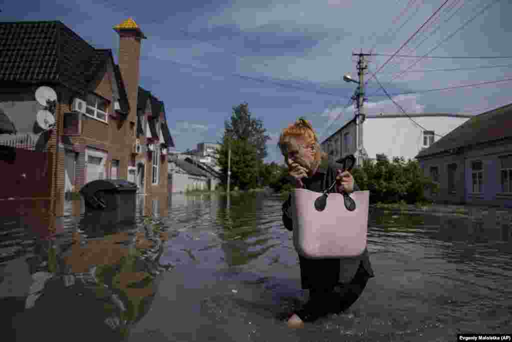 A woman makes her way through a flooded road in Kherson.&nbsp; The city, which had a prewar population of nearly 300,000 people, is now facing a new humanitarian disaster.&nbsp;Much of Kherson's infrastructure was destroyed&nbsp;during an eight-month Russian occupation. &nbsp;