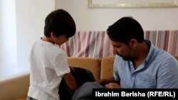 Arash Noori, refugjat afgan, duke përgatitur çantën e të birit për në shkollë.