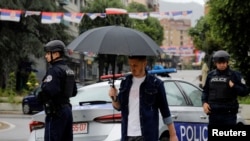 Një burrë duke kaluar pranë një veture të Policisë së Kosovës në veri të Mitrovicës.