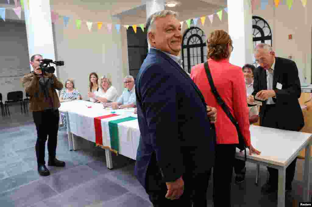 Premierul ungar Viktor Orban, însoțit de soția lui, Aniko Levai, așteaptă să voteze la o secție de de la Budapesta, Ungaria, 9 iunie 2024. Partidul său, Fidesz, nu este afiliat la un grup din Parlamentul European, dar speră să beneficieze în alegeri de o creștere a curentelor populiste și de extremă dreapta de pe continent.