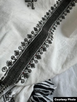 Punctele roșii, vizibile pe partea dreaptă a broderiei. Se observă că ele nu constituie un tipar și sunt cusute numai în câteva părți.