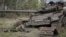The body of a Russian soldier is seen near a destroyed Russian tank in the newly liberated village of Storozheve in Ukraine's Donetsk region on June 14.