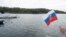 A member of Havana's Russian community held a flag as a Russian nuclear-powered submarine entered the bay of the Cuban capital in the last Russian naval visit, on June 12.