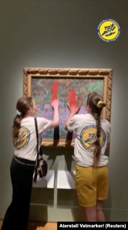 Klimatski aktivisti Aterstall Vatmarker (Obnovite močvare) razmazuju crvenu boju na zaštitnom staklu Monetove slike, izložene u Nacionalnom muzeju, u Stockholmu, Švedska, 14. juli 2023.