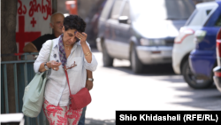 ქალი იწმენდს ოფლს შუბლზე თბილისის ქუჩებში, სადაც ტემპერატურამ განსაკუთრებით მაღალ ნიშნულს მიაღწია.