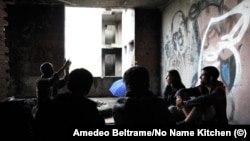 Emigrantët kinezë në një shtëpi të braktisur në Bihaq së bashku përfaqësuesit e organizatës No Name Kitchen. 