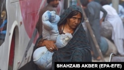 زن مهاجر افغان در حال بازگشتن از پاکستان به افغانستان