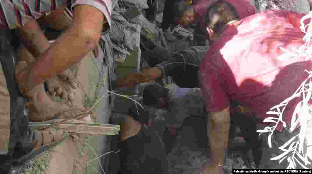 Ljudi rade na uklanjanju ruševina dok traže žrtve nakon eksplozije u gradu Gaza, 18. oktobra 2023.