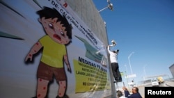 Калифорнияда кызамык оорусу тууралуу эскертүүнү көрүнөө жерге илип жатышат. Сүрөт иллюстрация үчүн колдонулду. 