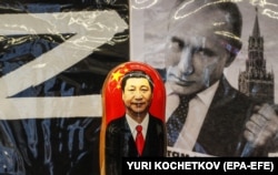 Moskvanın mərkəzindəki suvenir dükanında Vladimir Putinin şəklinin qarşısında üzərində Çin lideri Si Cinpinin portreti olan rus matryoşkası.