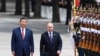 Președintele chinez Xi Jinpin (stânga) și președintele rus Vladimir Putin salută garda de onoare în timpul vizitei liderului rus la Beijing de anul trecut. 
