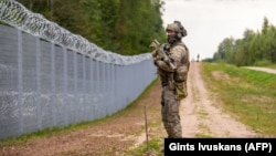 Латвійскі вайсковец каля мяжы зь Беларусьсю, жнівень 2023 году