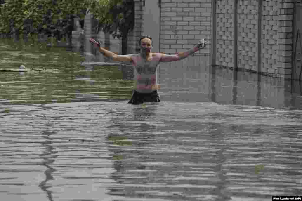 A resident gestures as he wades across the floodwaters in Kherson. Kyiv has accused Moscow of blowing up the huge Soviet-era dam on the Dnieper River, in what Ukrainian President Volodymyr Zelenskiy called an act of "terror."