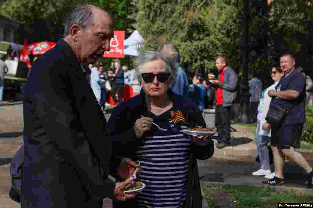 Женщина с георгиевской ленточкой на груди ест &laquo;солдатскую кашу&raquo;