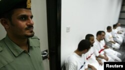 په دوبۍ کې یوشمېر زندانیان د ازادېدو په انتظار ناست دي، څنګ کې یې یو سرتېري ولاړ دی - پخوانی انځور.