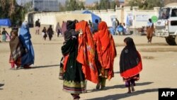 د یوې افغانې کورنۍ غړي په سپین بولدک کې د نوملیکنې مرکز پر لوري روان دي - د ډېسېمبر درېیمې انځور. 