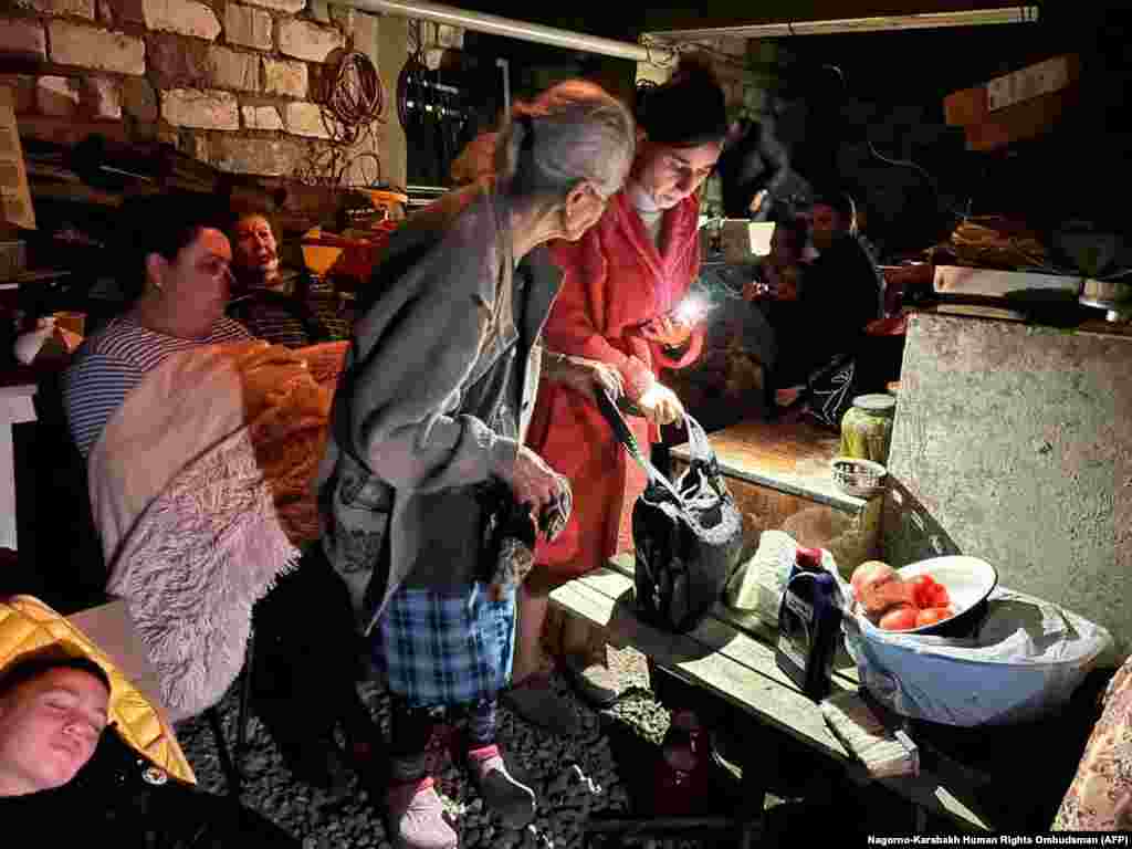 People huddle in a basement in Stepanakert on September 20.