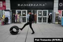 Қытайдағы "Қорғас" халықаралық шекара маңы ынтымақтастық орталығында жеңіл автокөлік шиналарын теуіп дөңгелетіп келе жатқан жігіт. 20 наурыз, 2024 жыл.