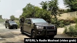 د امنیتي سرتېرو ګاډي په کورمه کې له یو سړکه تېرېږي - پخوانی انځور.