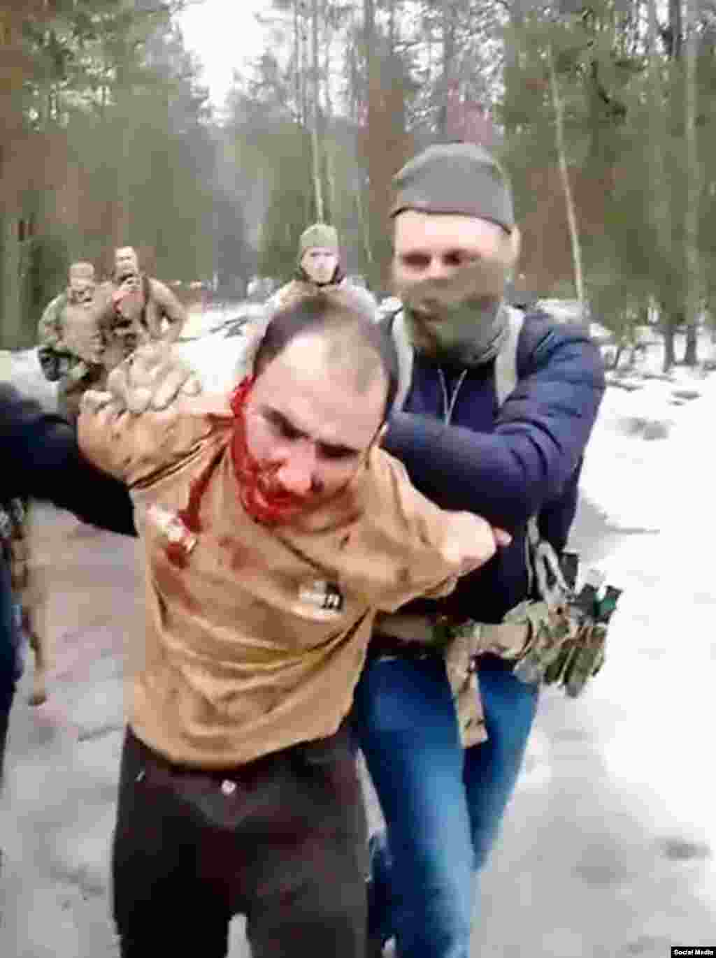 Saidakram Rajabalizoda is seen as he is led away after reportedly having his ear sliced off by uniformed men who caught him in a forest in Russia's Bryansk region on March 23. The Russian Grey Zone Telegram channel, which is connected to the Wagner group, published a video purportedly showing Rajabalizoda&rsquo;s ear being cut off and security agents trying to force him to eat it. A man in the video yells at the suspect: &ldquo;Chew, bastard! I will cut you open and shove it into your mouth.&rdquo;