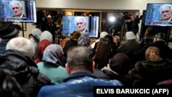 Боснійські мусульмани, які вижили після різанини в Сребрениці, дивляться пряму трансляцію оголошення остаточного вироку у справі Радована Караджича, Поточари (біля меморіалу у Сребрениці), 20 березня 2019 року