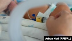 Përmes shiringës, nëna ushqen beben e saj me qumësht gjiri.