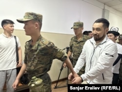 Азамат Ишенбеков менен Актилек Капаров Ленин райондук сотуна алынып келаткан учур. 7-июнь, 2024-жыл.