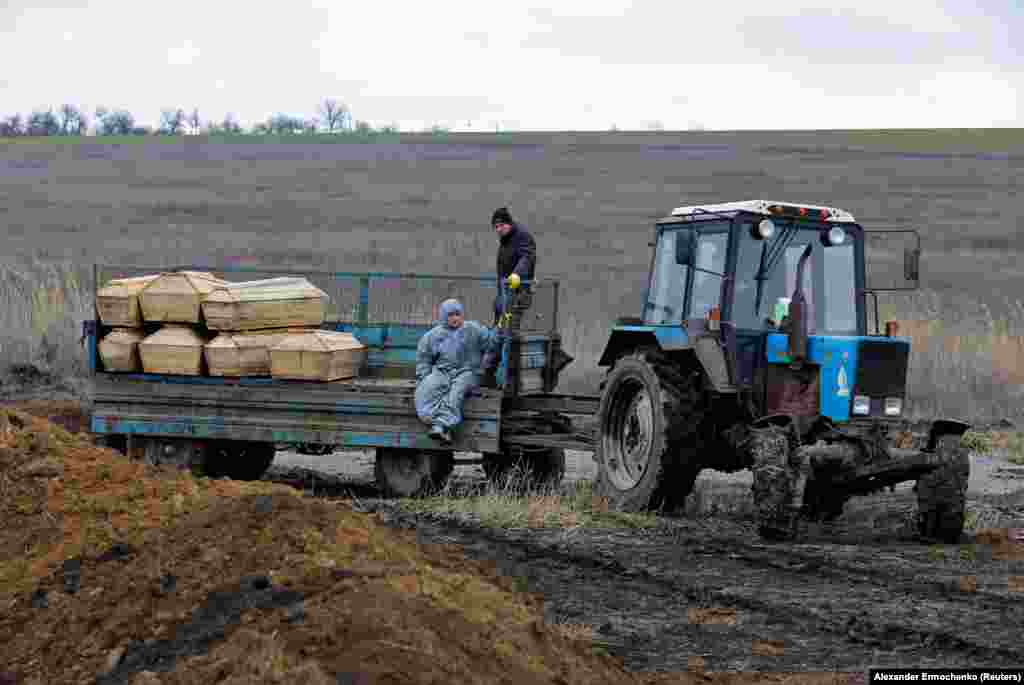 Gravediggers ride with coffins being transported to a cemetery on the outskirts of Mariupol. The bodies of civilians were reportedly being discovered in the rubble of buildings long after the Russian siege had ended. Many civilians sheltered from the fighting in the basements of apartment blocks.
