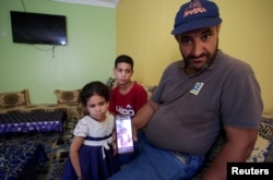 Иман Хелифтин атасы Амар кызынын кичине кезиндеги сүрөтүн көрсөтүп жатат. 2-август, 2024-жыл. Сүрөт: REUTERS